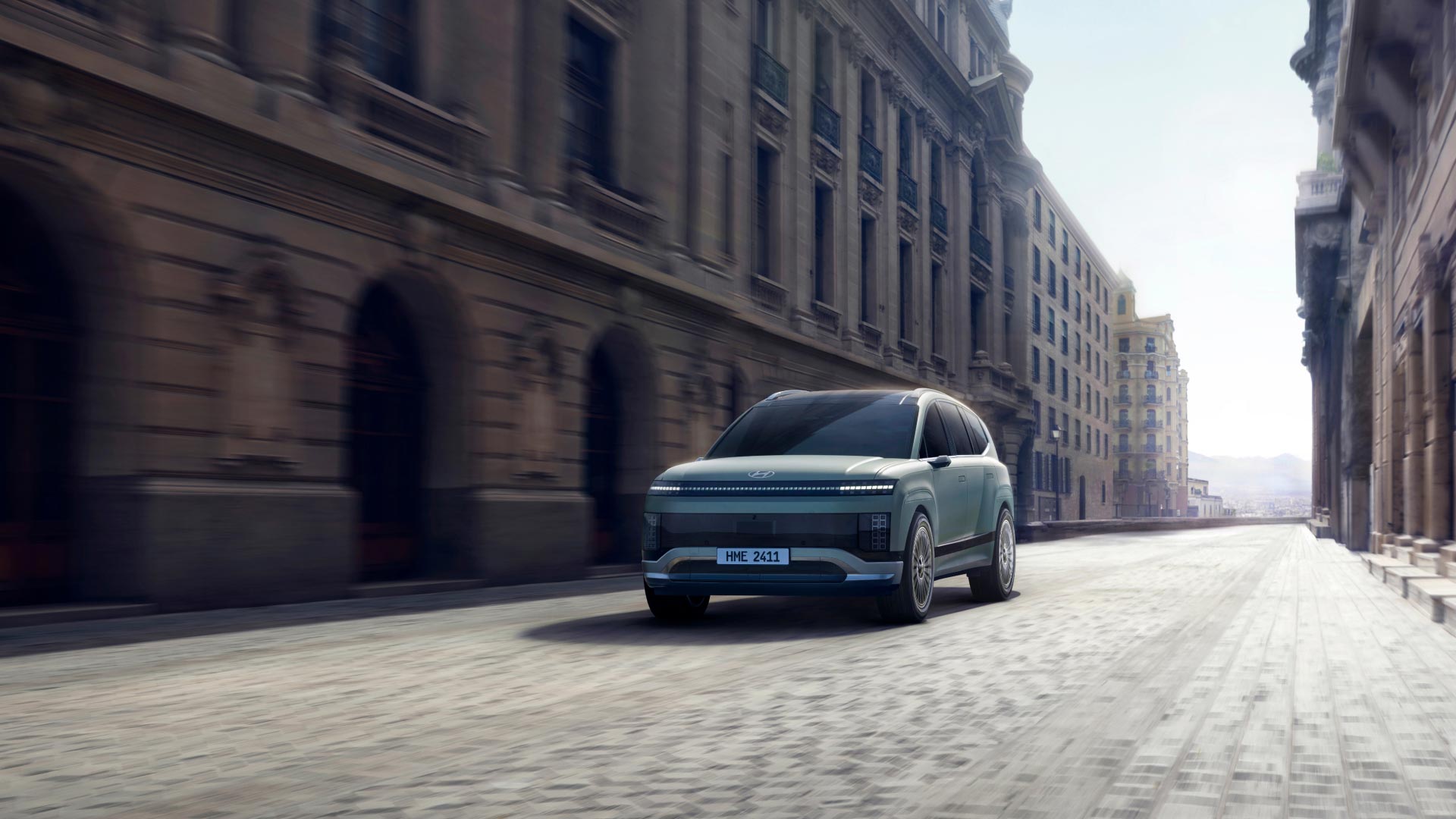Official Hyundai IONIQ 9 exterior press image showing the SUV from the front three-quarter angle in a city setting
