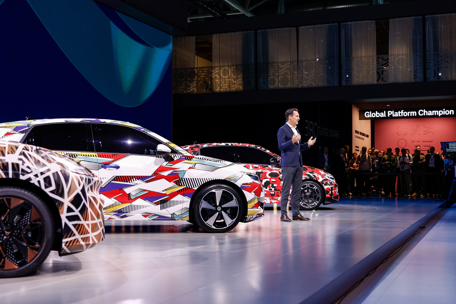 Camouflaged Volkswagen Group electric cars on stage during an official presentation