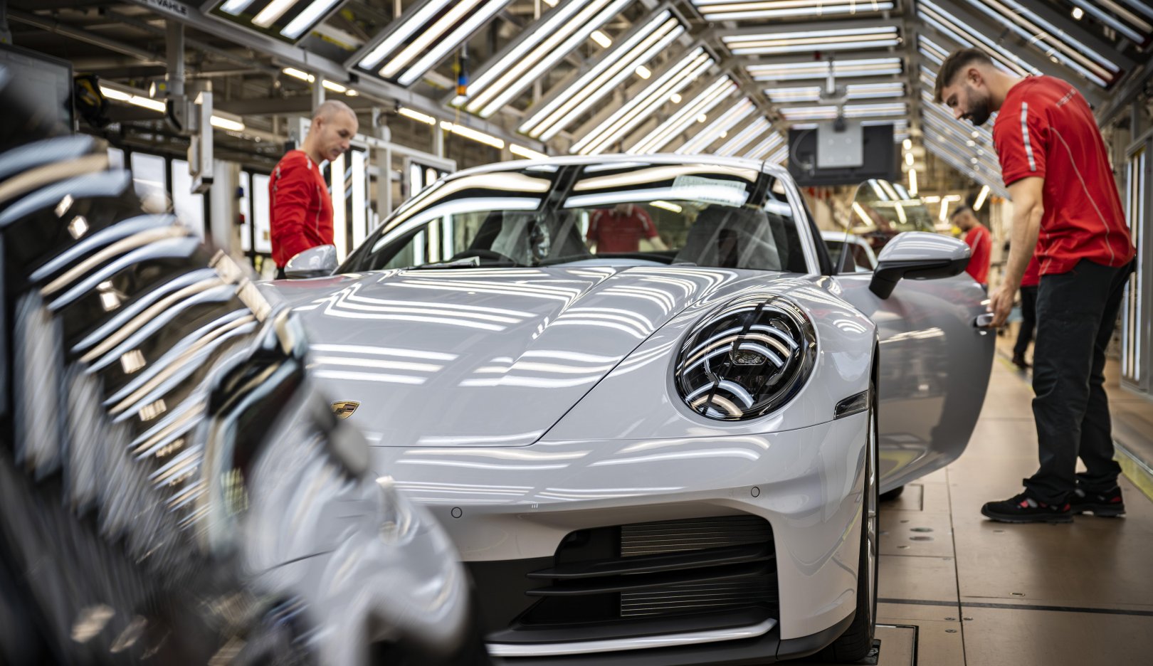 Porsche employees assembling a white 911 at the Zuffenhausen factory