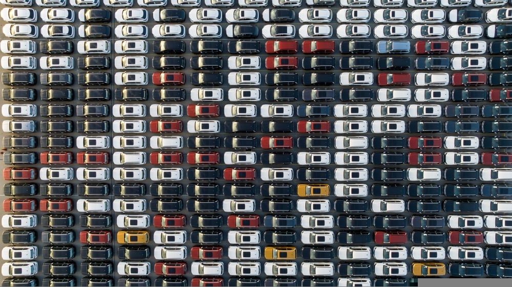 Rows of vehicles at a distribution lot illustrating global electric-vehicle sales data for August 2026