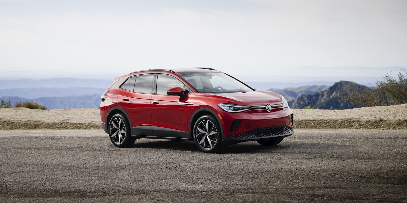 Red Volkswagen ID.4 parked in front three-quarter view at a mountain overlook