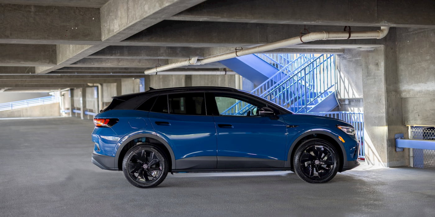 Official Volkswagen photo of a blue ID.4 electric SUV in side profile inside a parking structure