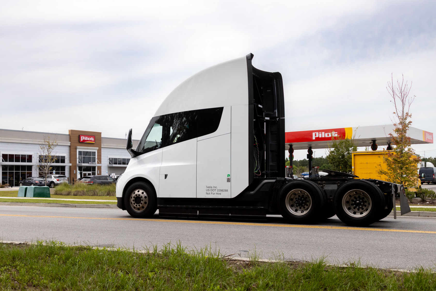 Official Pilot photograph of a white Tesla Semi in side profile outside a Pilot travel center
