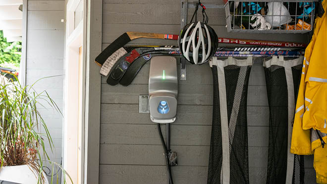 Wall-mounted EV charging equipment with a green indicator in a home garage, photographed by BC Hydro