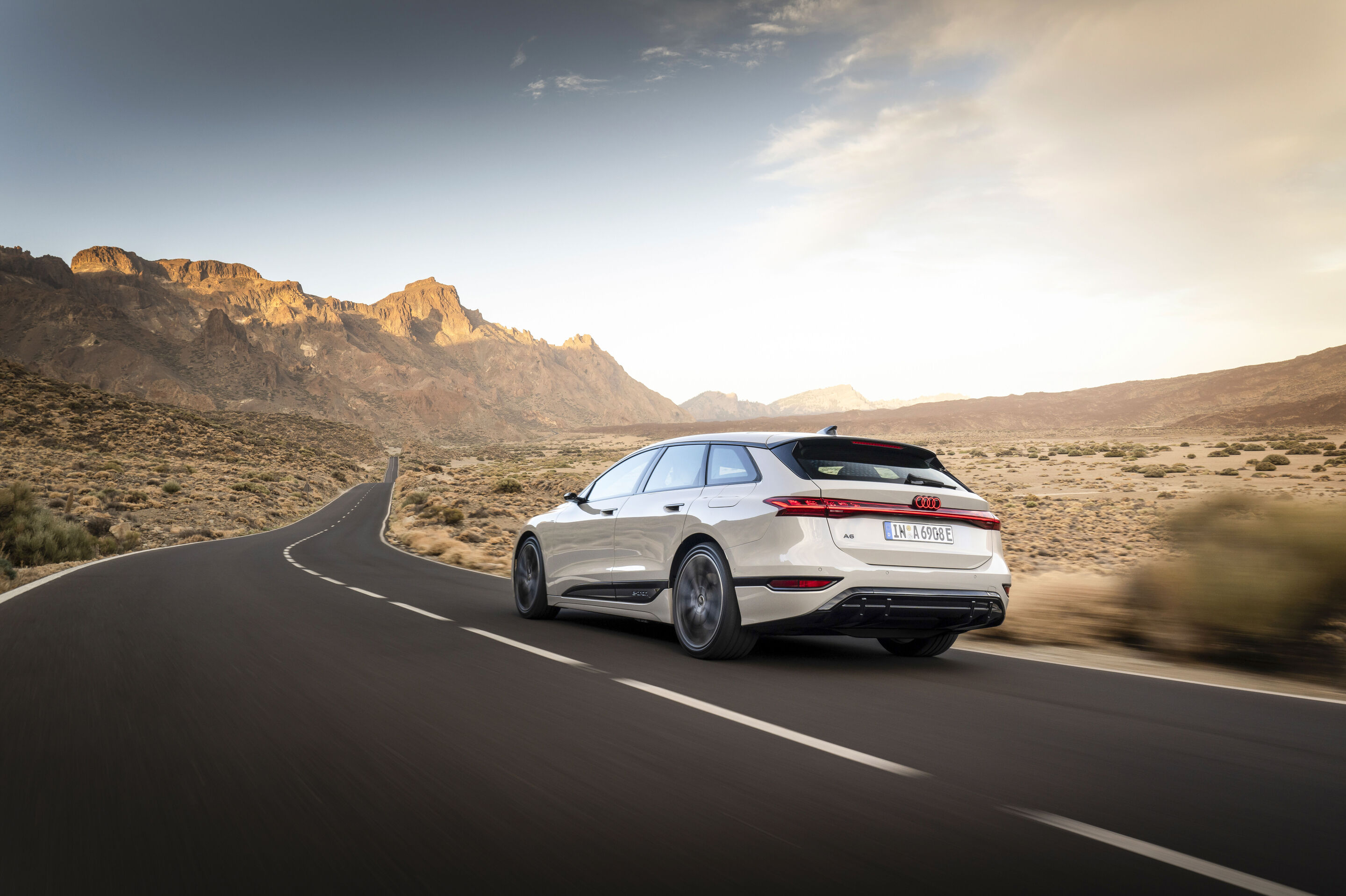 Audi A6 Avant e-tron official rear three-quarter rolling image in a mountain landscape