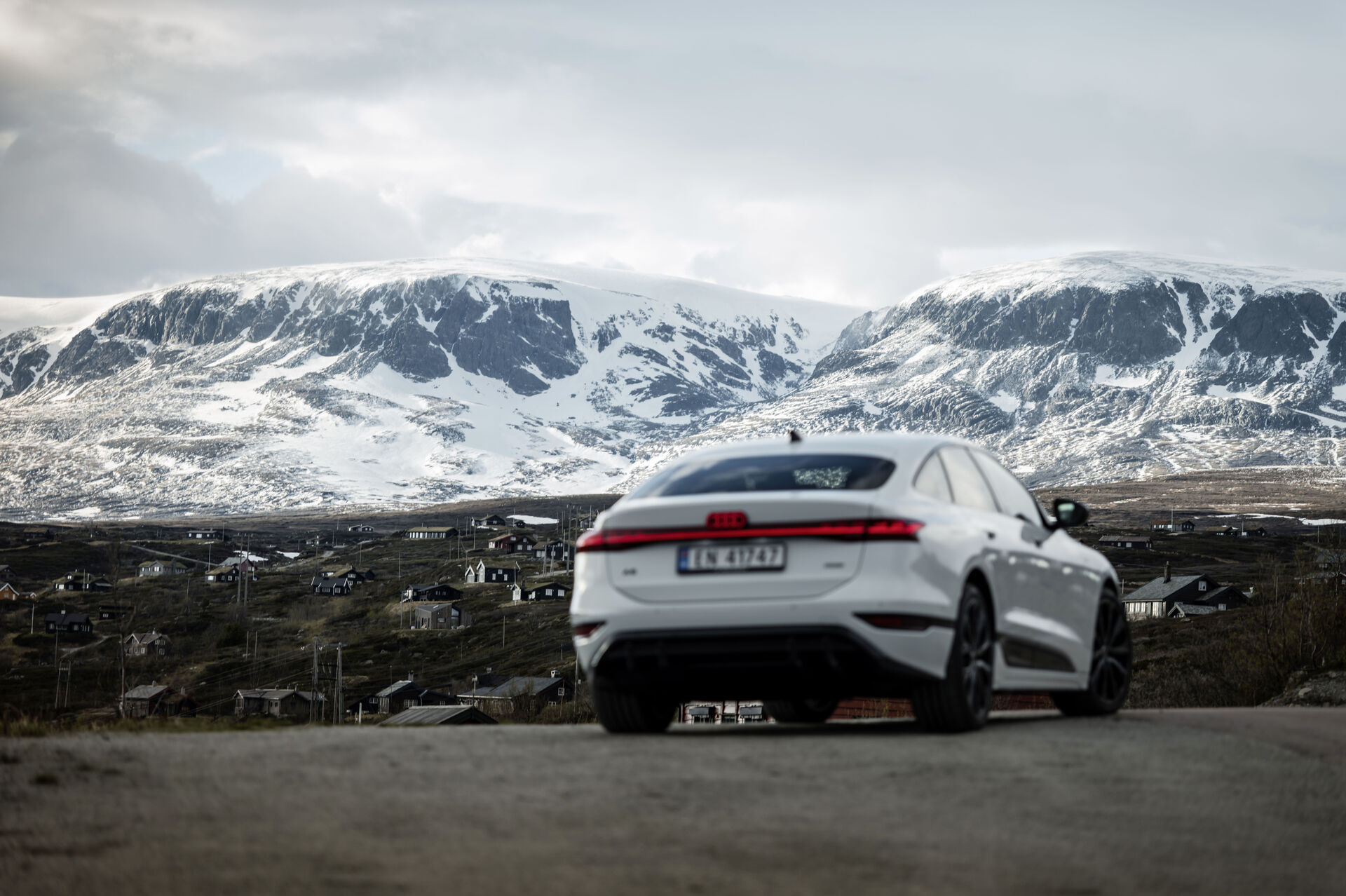 Audi A6 e-tron rear three-quarter official image with snowy mountains in the background