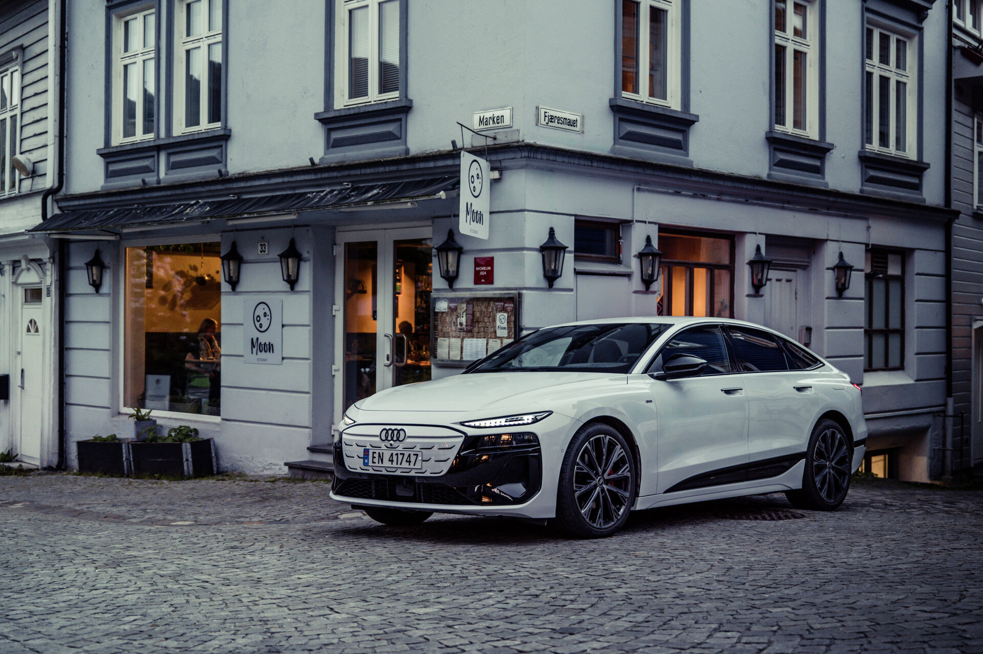 Audi A6 e-tron front three-quarter official image on a cobblestone street