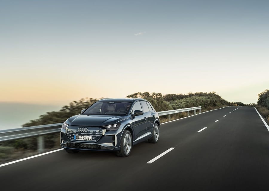 Audi Q4 SUV e-tron driving on a highway at sunset