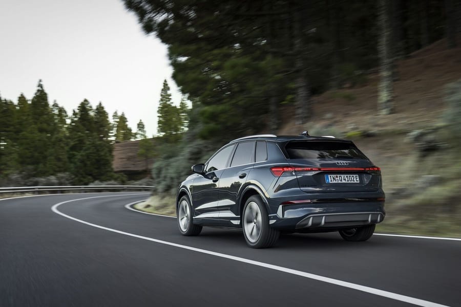 Audi Q4 SUV e-tron driving away on a curving forest road