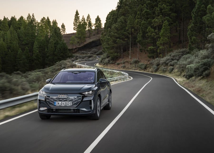 Audi Q4 SUV e-tron driving toward the camera on a forest road