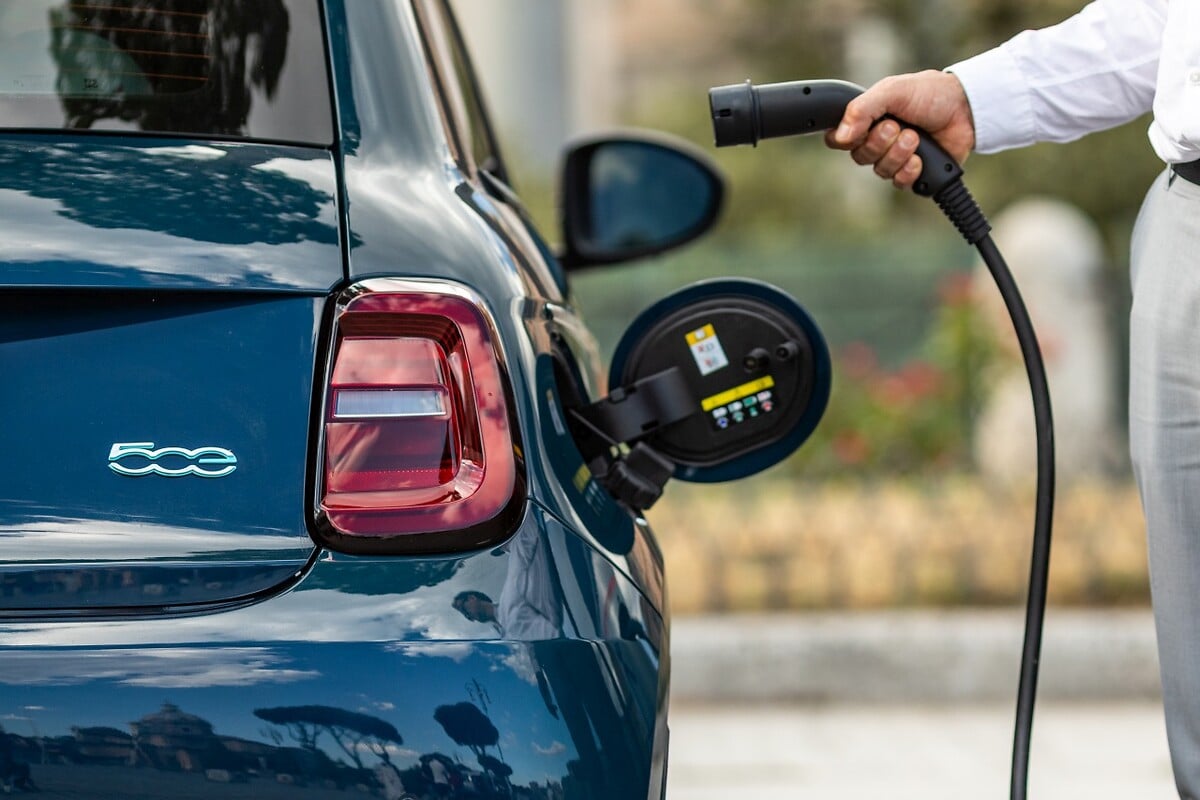 Charging connector being inserted into a blue Fiat 500e
