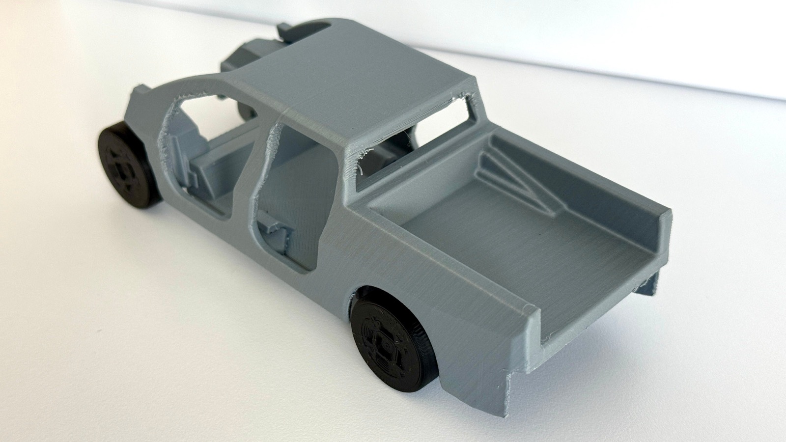 Close-up of a 3D-printed Ford Universal EV body and cabin model with wheels
