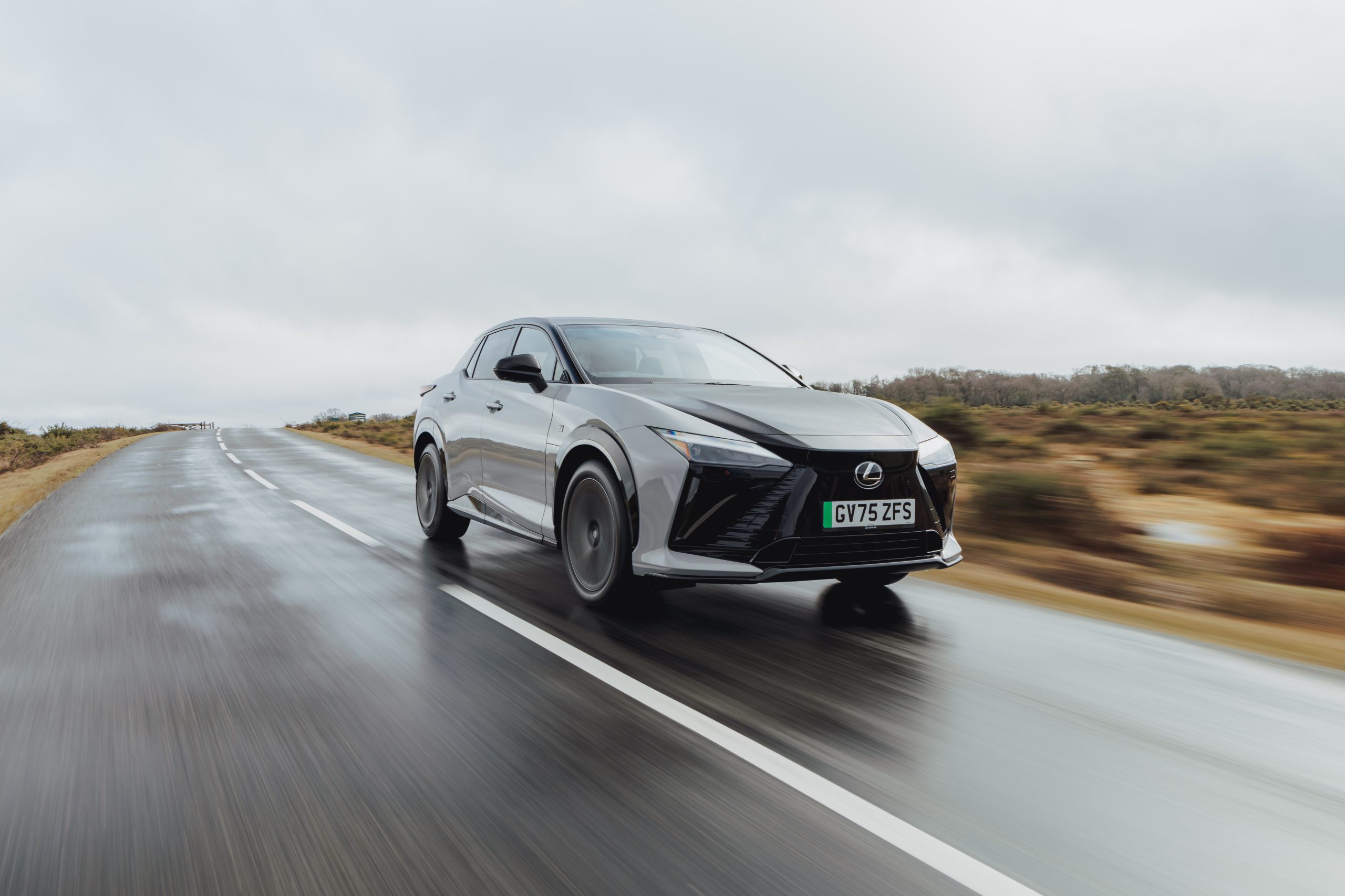 Silver 2026 Lexus RZ 550e F Sport driving on a wet road